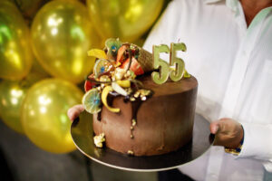 Birthday cake with candles on balloons background.