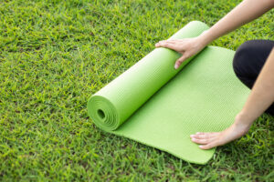 Unrolling yoga mat in the park