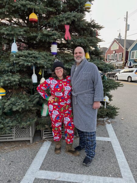 Two people in pajamas in front of a Christmas tree in Kennebunkport Maine.