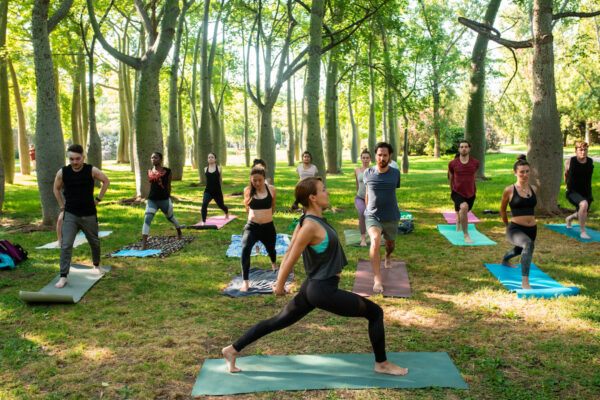 yoga teacher teaching a group of people at the park