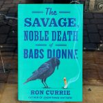 Blue green book cover in bookshop window.